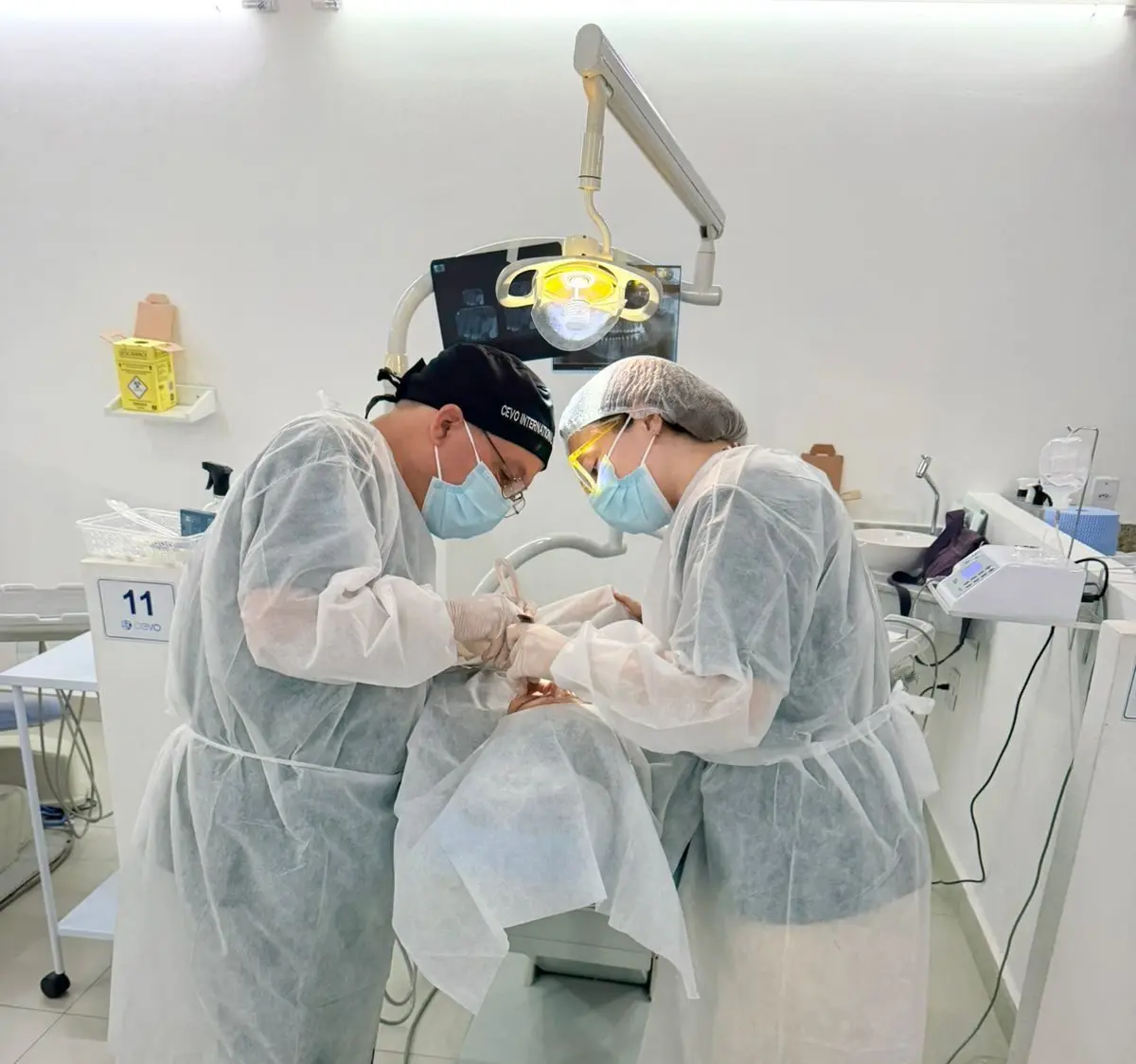 Two surgeons in white gowns operating on a patient at the Brazilian centre