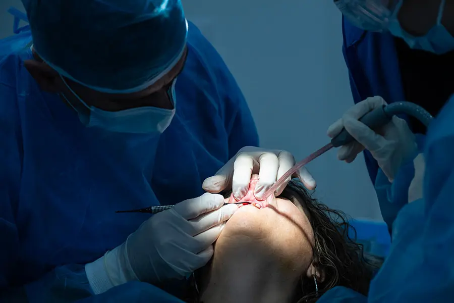 A surgeon and an assistant working on an upper arch